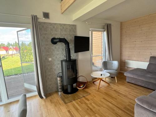 a living room with a wood stove and a couch at Jaśminowy Sad in Mikołajki