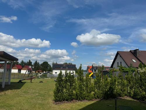 a park with a playground and houses and a cloudy sky at Jaśminowy Sad in Mikołajki