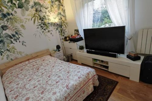 une chambre avec un lit et une télévision à écran plat dans l'établissement T2 meublé 1 er étage dans un quartier calme à PARIS 17, à Paris