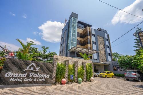 a hotel with a sign in front of a building at Grand Valonia Hotel Cafe & Park Jember in Jember
