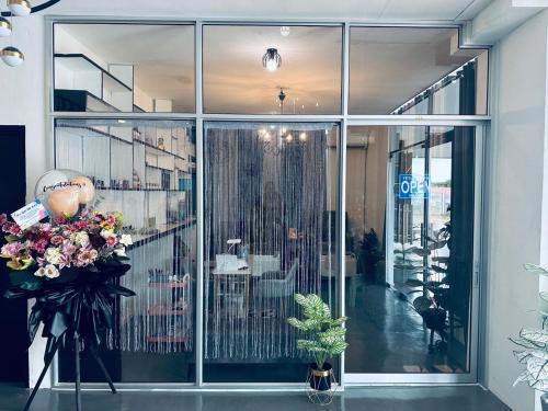 a lobby with a large glass window with flowers in a vase at Kuu Inn Hotel in Arau