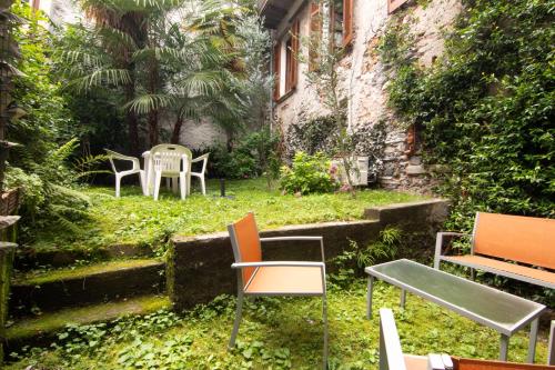 a group of chairs and tables in a yard at Oikos Dafne in Gravedona
