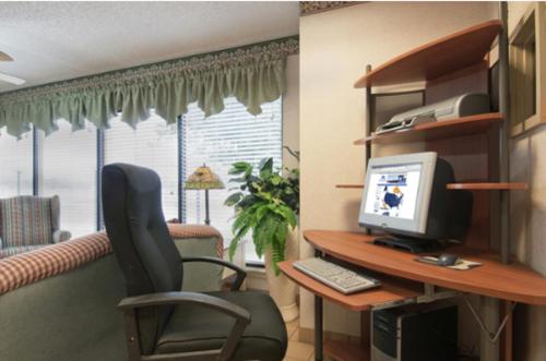 a desk with a computer and a chair in a room at Five Star Inn Burleson in Burleson