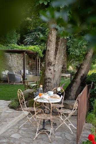 a table and chairs in a garden next to a tree at La Casa sul Forte in Seravezza