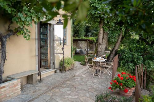 a patio with a table and chairs and flowers at La Casa sul Forte in Seravezza