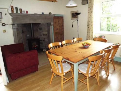 a dining room with a table and chairs and a fireplace at Skellgill House in Askrigg