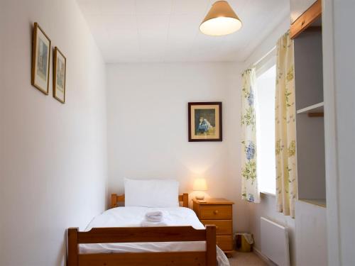 a small bedroom with a bed and a window at The Old Reading Room in Bamburgh
