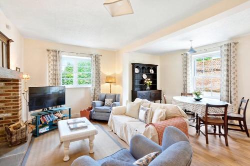 a living room with a couch and a tv at Moat Cottage, Newby Hall, Ripon, North Yorkshire in Copt Hewick