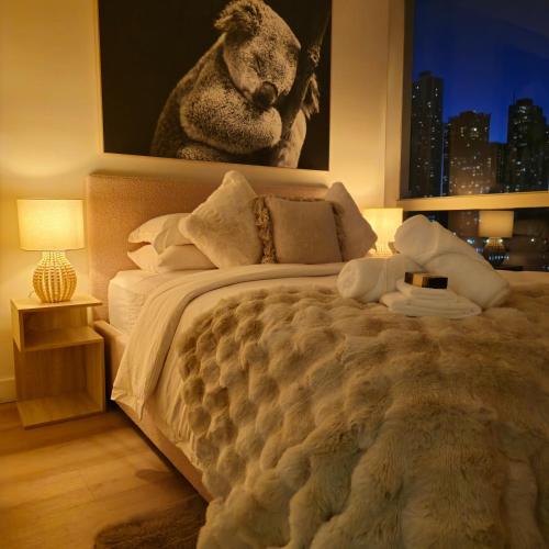 a bedroom with a large bed with a picture on the wall at Prestige Dwellings QV1 in Melbourne