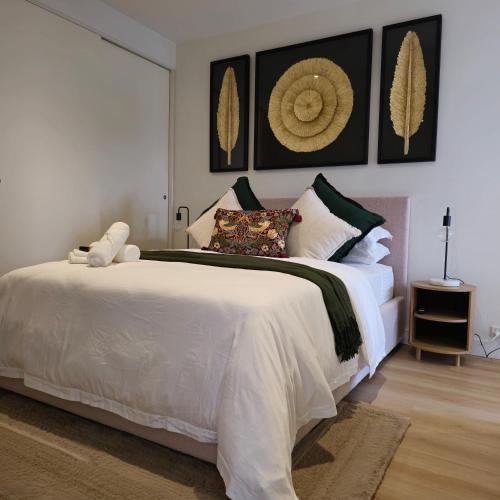 a bedroom with a large white bed with pillows at Prestige Dwellings QV1 in Melbourne