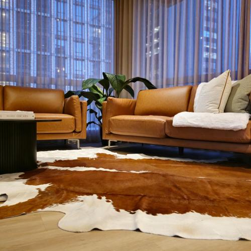 a living room with two brown couches and a table at Prestige Dwellings QV1 in Melbourne