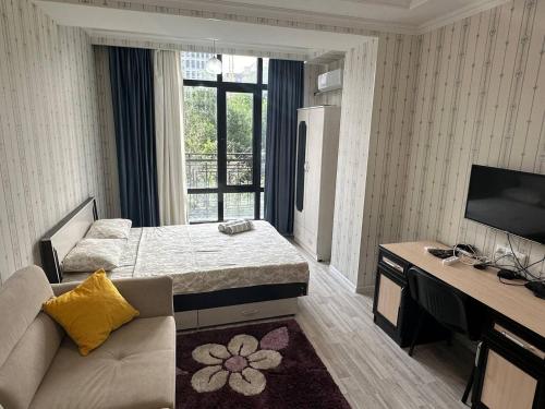 Cette chambre comprend un lit, un canapé et une télévision. dans l'établissement apartments "Harmony" on sydykova st 156а, à Bishkek