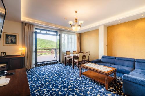 a living room with a couch and a table at Hotel Dziki Potok Karpacz Konferencje & SPA in Karpacz