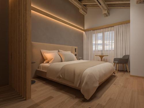a bedroom with a large bed and a window at Naturae Lodge Wellness & Spa in Alleghe