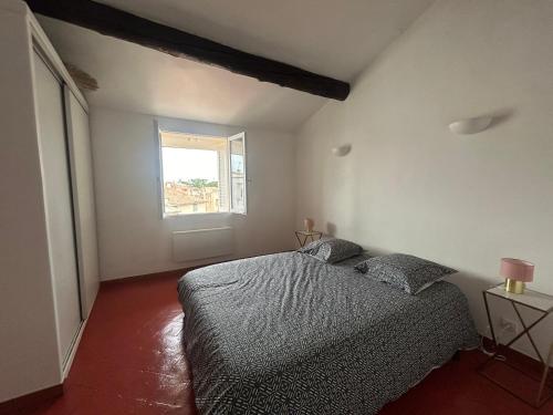 une chambre avec un lit et une fenêtre dans l'établissement Namasté, à Aix-en-Provence