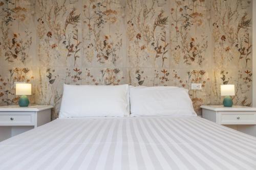 a bedroom with a large bed with two nightstands and two lamps at Hotel Donatella in Posada