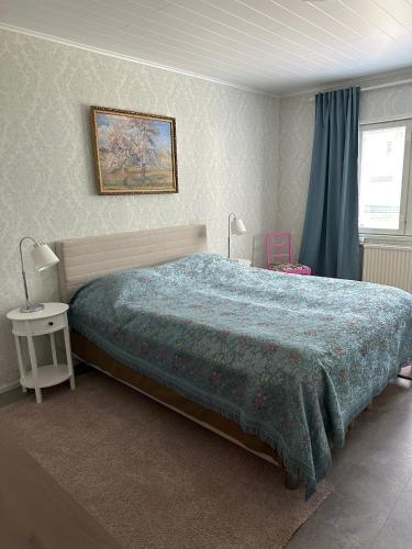 a bedroom with a bed with a green comforter at Iiris in Imatra