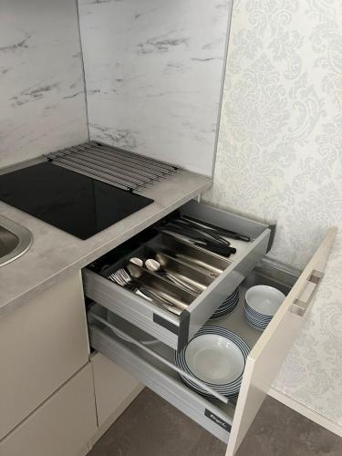 a kitchen drawer with plates and utensils in it at Iiris in Imatra