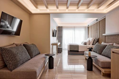 a living room with a couch and a bed at Amazon Mykonos Suites & Spa in Agios Ioannis Mykonos
