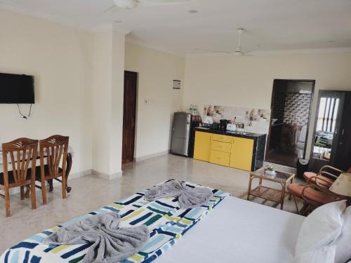 a living room with two beds and a kitchen at Primavera Holiday Homes-FAMILY RUN GOAN GUEST HOUSE in Candolim