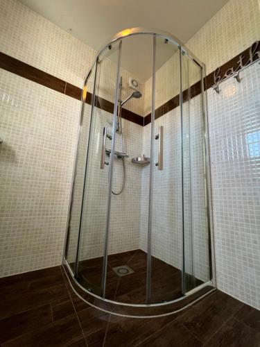 una ducha con mampara de cristal en un baño en Texelheerlijk 2, en De Koog