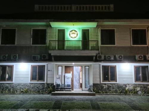a building with a sign on the front of it at night at Hotel Honai by Capital in Binong