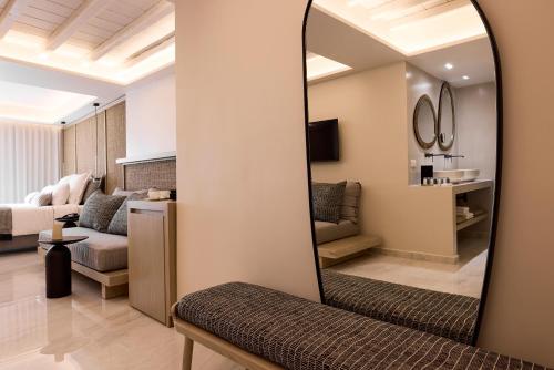 a living room with a mirror and a couch at Amazon Mykonos Suites & Spa in Agios Ioannis Mykonos