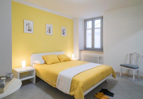 ein Schlafzimmer mit einem Bett und einer gelben Wand in der Unterkunft Chery Bed & Breakfast in Riva San Vitale