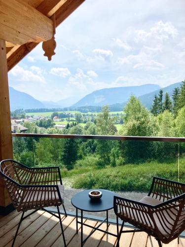 two chairs and a table on a deck with a view at Alpen Luxury Lodge, MARIAZELL - Adults only in Mariazell