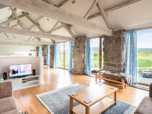 a living room with wooden floors and large windows at Awel Deg in Arthog