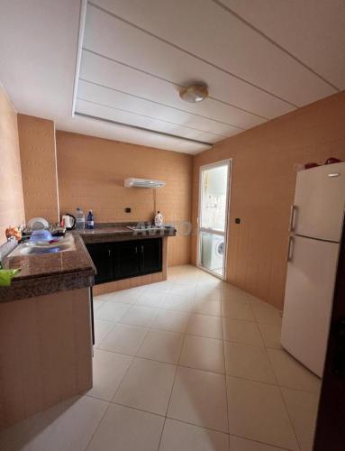 a kitchen with a white refrigerator and a counter top at Appartement Centre Ville in Kenitra