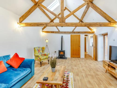a living room with a blue couch and a wood stove at The Granary - Uk38980 in Llandyssil