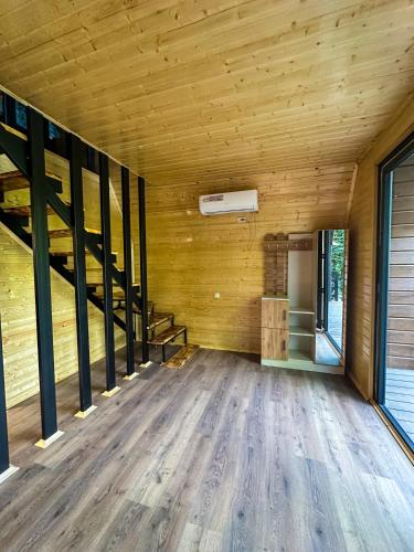an empty room with wooden walls and wooden flooring at Martvili canyon cottage in Martvili
