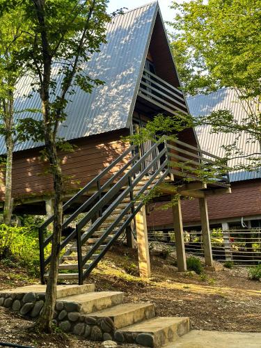 a house with a staircase leading up to a roof at Martvili canyon cottage in Martvili