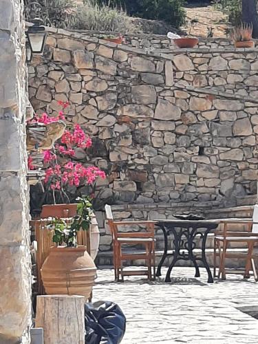 a stone wall with a table and benches and flowers at Casa Picimenti Zakynthos Marathias Swimming Pool Ground Floor Villa in Marathias