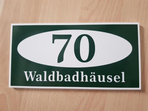 a sign on a wall with the number at Waldbadhäusel Naturbad-Bungalow in Neuwiese