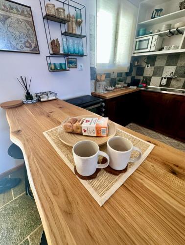 a table with two coffee cups and a bagel on it at SeaTerra Boutique suite in Kalamos