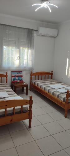 a room with three beds and two tables in it at aggelos home in Kato Alepochori