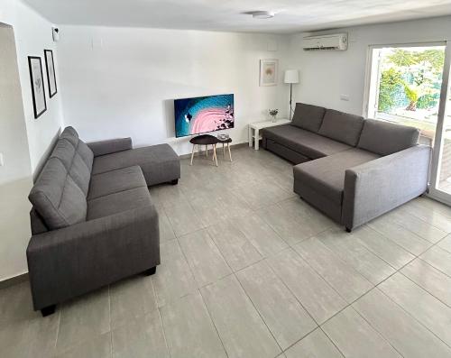 a living room with two couches and a tv at Chalet con piscina privada en Alcocebre in Alcossebre
