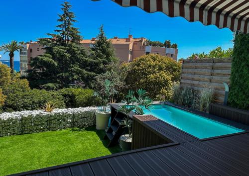 une petite arrière-cour avec piscine et pelouse dans l'établissement Escapade balnéaire, Piscine privée et à deux pas des plages, à Cannes