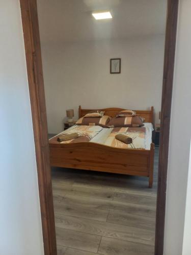 a bedroom with a bed and a mirror at Oázis Apartman in Sárospatak