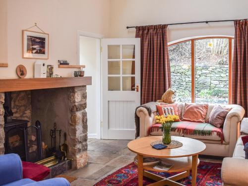 a living room with a couch and a fireplace at Gushat Cottage in Strathtay
