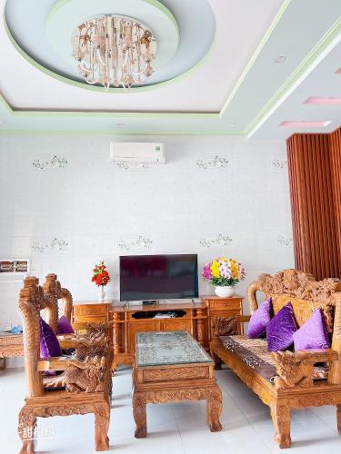 a living room with two chairs and a tv at Nhà nghỉ 72 in Long Hai