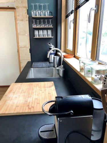 une cuisine avec un évier et un comptoir avec une machine à coudre dans l'établissement Studio-Loft lumineux et calme, à Bordeaux