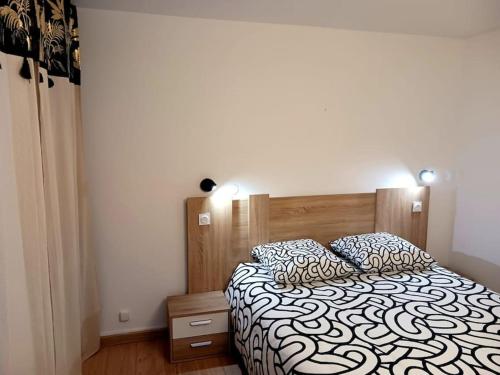 une chambre avec un lit avec une couette noire et blanche dans l'établissement Appartement T2 avec piscine mer, à Vallauris