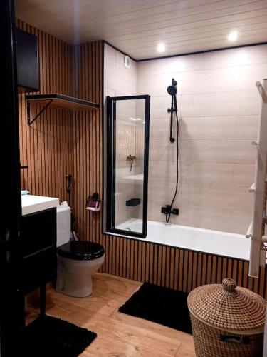 La salle de bains est pourvue d'une douche, de toilettes et d'une baignoire. dans l'établissement Appartement T2 avec piscine mer, à Vallauris