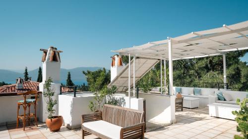 a patio with white furniture and a pergola at Totelya Hotel in Akyaka