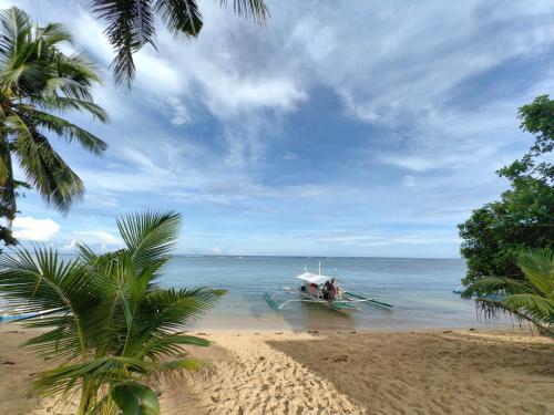 a boat in the water on a beach at Ocam Ocam Casadyan Inn in New Busuanga