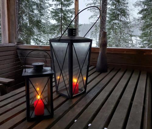 two lanterns on a porch in front of a window at Koivurannan Lomamökit Kataja in Mikkeli