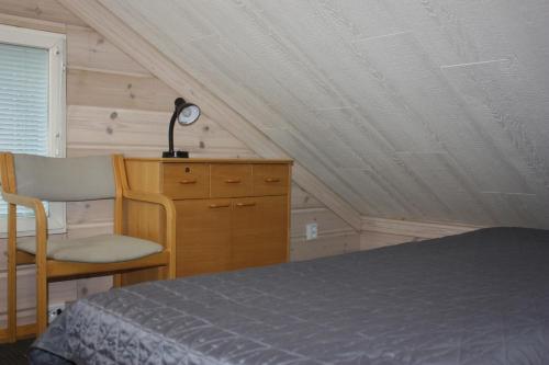a bedroom with a bed and a desk and a chair at Koivurannan Lomamökit Kataja in Mikkeli